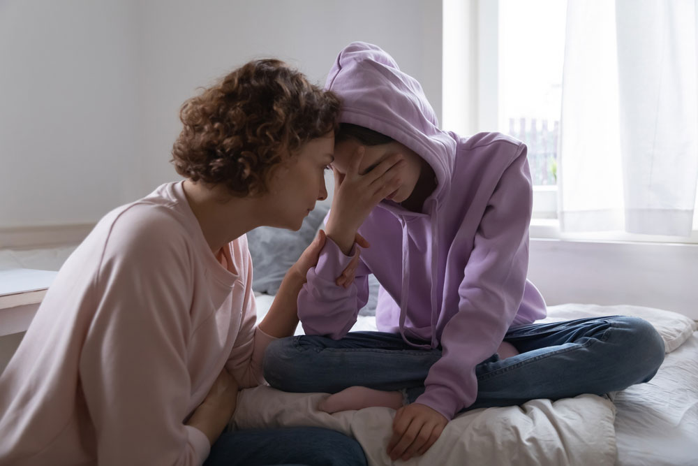 Worried parent comforting teen 