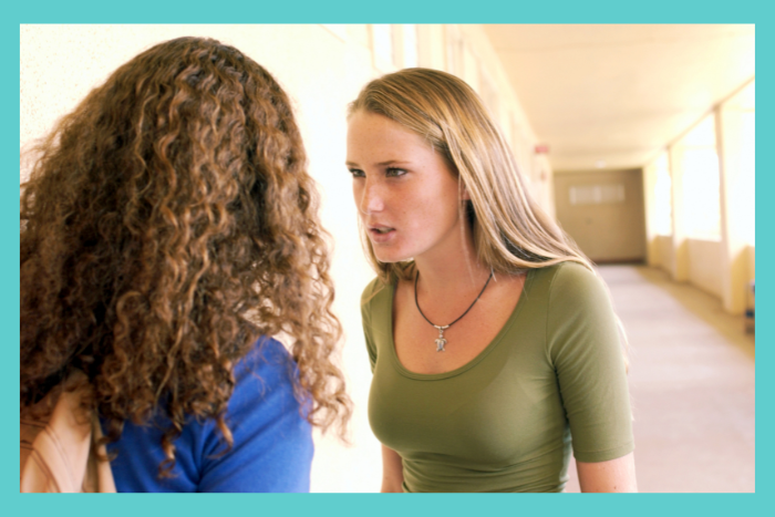 two friends fighting, arguing. one girl looks like a bully and is coercive. the other girl is scared. toxic friendships